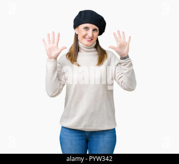 Reife Frau mittleren Alters tragen winter Pullover und Baskenmütze über isolierte Hintergrund angezeigt und zeigen mit den Fingern Nummer zehn, während lächelnd confid Stockfoto