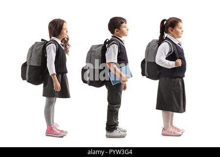 Volle Länge Profil Aufnahme von Schulkindern in Linie auf weißem Hintergrund warten Stockfoto