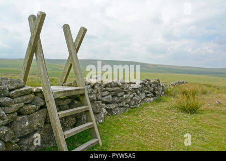 Aus Bruchstein Mauer bei Stonetor Hügel am Rande von Chagford Gemeinsame auf Dartmoor, mit Watern Tor auf dem entfernten Ridge Stockfoto