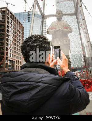 Canary Wharf, London, Großbritannien, 30. Okt 2018. Ein Passant nimmt Fotos der Installation. Jeder erinnert, Jubilee Plaza - Tausende von Mohn durch die Öffentlichkeit in der gesamten Britischen flattern um den Soldaten gewidmet, einer Hommage an alle und jeden für ihre Opfer. Die Erinnerung Art Trail, in Verbindung mit der Royal British Legion, ist kostenlos und kann von der Öffentlichkeit bis zum 11. November in Canary Wharf. ANA (Armee, Marine und Luftwaffe) Credit: Imageplotter Nachrichten und Sport/Alamy Live News besucht werden Stockfoto