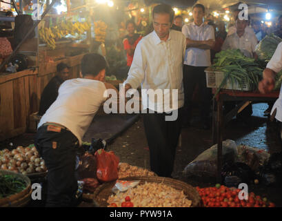 Bogor, West Java, Indonesien. 30 Okt, 2018. Präsident Joko Widodo (C) bei seinem Besuch in den traditionellen Markt von Bogor Stadt gesehen zu haben. Präsident Joko Widodo beim Sprechen mit Händlern, die er Ihnen über die Preise, die sie ihre Waren verkaufen. Der Präsident betonte, dass der Preis für Grundnahrungsmittel waren stabil ist. Credit: Adriana Adinandra/SOPA Images/ZUMA Draht/Alamy leben Nachrichten Stockfoto