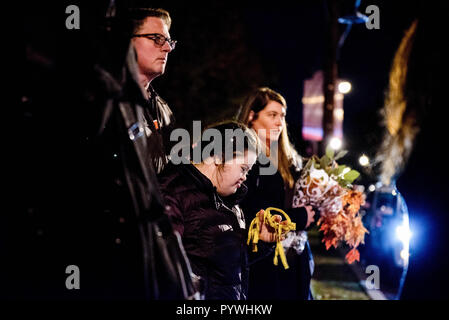 Pittsburgh, USA. 29 Okt, 2018. Anders - Mädchen im Gebet mit Hausmeister und Frau mit Blumen aktiviert. Nach dem Schießen am Baum des Lebens Synagoge in Squirrel Hill, Pittsburgh, PA, Trauer erfolgt, mit der Polizei, um die größere Gemeinschaft kommt zusammen mit Musik und Heilung. Credit: Aaron Jackendoff/SOPA Images/ZUMA Draht/Alamy leben Nachrichten Stockfoto