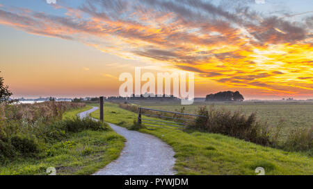 Wicklung Radweg durch die holländische Polderlandschaft unter schönen Sonnenuntergang Stockfoto