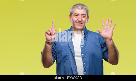 Gut aussehender älterer Mann über isolierte Hintergrund angezeigt und zeigen mit den Fingern Nummer sechs, während lächelte zuversichtlich und fröhlich. Stockfoto