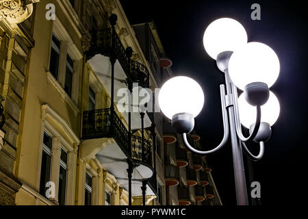 Low Angle View an die Fassade eines alten Hauses mit einer Straßenlaterne in Front in der Nacht. Stockfoto