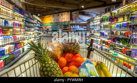 Ostern shopping Lebensmittelgeschäftkarre zu einem bunten Supermarkt mit Lebensmittel als aus der Sicht des Kunden gesehen Stockfoto