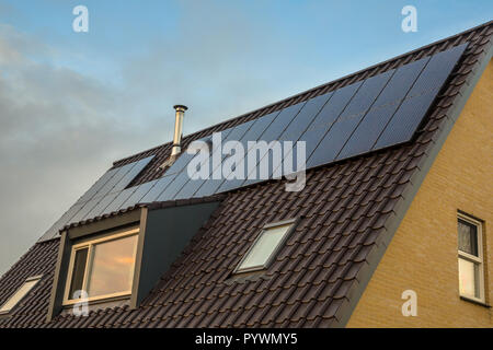 Diskrete Solar Panels in der gleichen Farbe wie Dachziegel und Dachgauben auf einem Haus Stockfoto