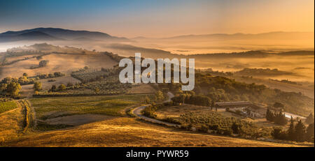 Die malerische Landschaft in der Nähe von Florenz mit Bauernhöfen und einem Dorf an einem nebligen Morgen im August, Italien Stockfoto