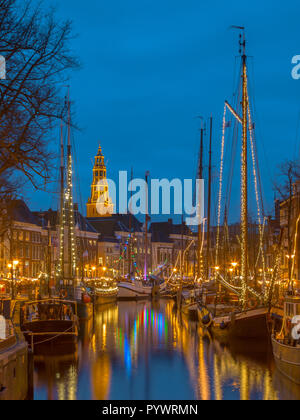 Historische Segelschiffe vor Anker im River Quay in Groningen Innenstadt auf der jährlichen Winterwelvaart Festival rund um Weihnachten. Stockfoto