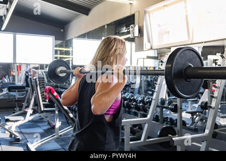 Junge passende Frau an der Turnhalle tun heavylifting Übung. Weibliche Athleten bei einem Fitnessraum, Arbeiten mit Langhantel Stockfoto