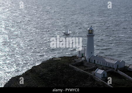 Leuchtturm South Stack auf der wunderschönen walisischen Insel Anglesey. Die Sonne scheint auf den Wellen des irischen Meeres, während dieses dramatische Gebäude Wache steht. Stockfoto