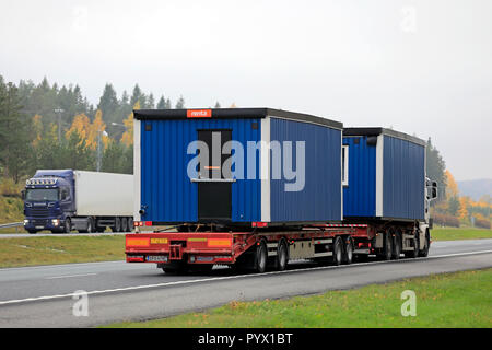 Salo, Finnland - 12. Oktober 2018: Zwei tragbare Kabinen auf LKW-Anhänger an der Autobahn mit Lastwagen transportiert an einem nebligen Tag im Herbst. Stockfoto