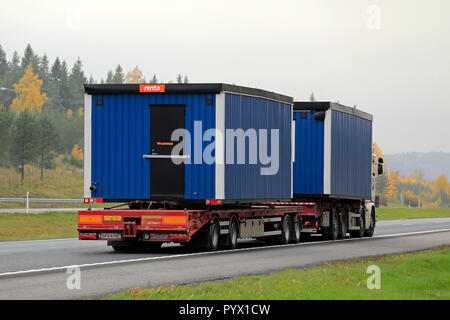 Salo, Finnland - 12. Oktober 2018: Zwei tragbare Kabinen auf LKW-Anhänger an der Autobahn mit Lastwagen transportiert an einem nebligen Tag im Herbst. Stockfoto