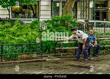 New York City, USA, Mai 2018, ein Polizist auf seine Pause ein Bild von einem Eichhörnchen im Madison Square Park Stockfoto