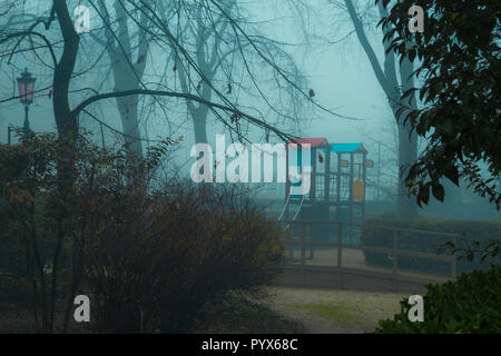 Creepy Spielplatz im Wald an einem nebligen Morgen Stockfoto