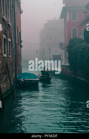 Gondel Fahrt auf den Kanälen von Venedig Italien an einem nebligen Morgen (Menschen bei der Arbeit) Stockfoto