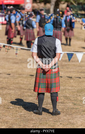 Ein Schotte trägt einen Kilt und eine Baseball Kappe schaut witzig und komisch. Nicht angepasste Kleidung und unpassende Kleidung. Stockfoto