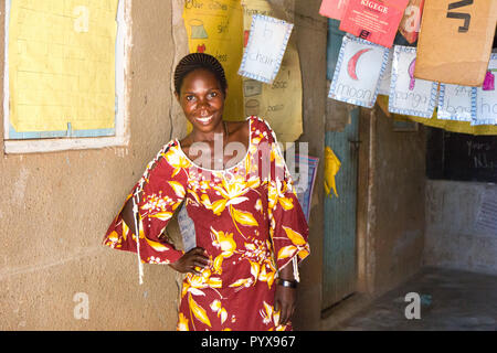 Lubanyi, Buikwe, Uganda. 28. April 2017. Eine schwarze ugandischen Lehrerin lächelnd. Sie ist in einer Grundschule Klassenzimmer. Stockfoto