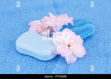 Bunte Seifen und Blumen auf blau Handtuch. Stockfoto