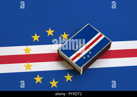 Cabo Verde Flag wird abgebildet auf eine Streichholzschachtel, die auf eine grosse Fahne liegt. Stockfoto