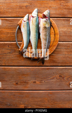 Frischen Fisch fangen liegt auf einem Schneidebrett auf einem Holztisch. Ansicht von oben kopieren Raum Stockfoto