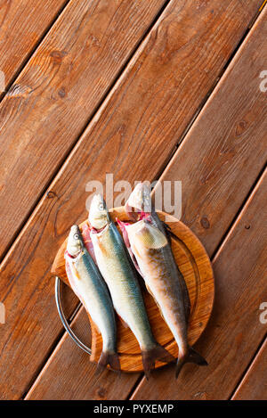 Frischen Fisch fangen liegt auf einem Schneidebrett auf einem Holztisch. Ansicht von oben kopieren Raum Stockfoto