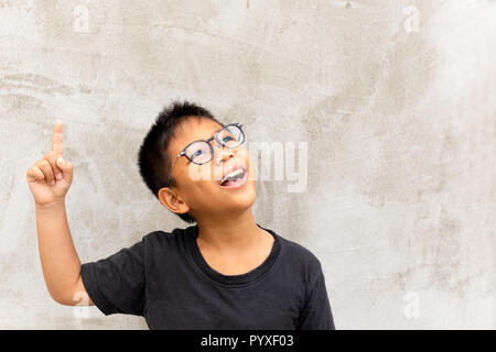 Wenig asiatischen Jungen lächelnd mit dem Finger nach oben. Stockfoto