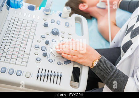 Erwachsene Frau Doktor scannen Schiffe auf dem Hals mit Ultraschall Gerät scannen. Selektiver Fokus Stockfoto