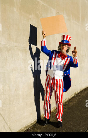 Eine unle SAM-Figur mit einem leeren Zeichen, als ob er Betteln vor. Ihre eigene Nachricht hinzufügen. Stockfoto