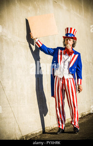 Eine unle SAM-Figur mit einem leeren Zeichen, als ob er Betteln vor. Ihre eigene Nachricht hinzufügen. Stockfoto