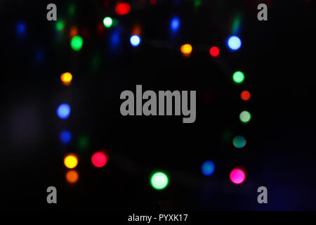 Rahmen von vielen glänzenden bunten bokeh Kreise auf Schwarz. Neues Jahr abstrakte verschwommenen Hintergrund Stockfoto