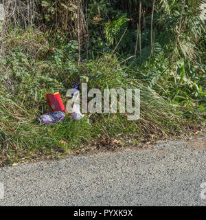 Streckenabschnitt einer verstreuten Landstraße. Konzeptstreu am Straßenrand UK. Sorgen Sie für Ordnung in Großbritannien, Plastikmüll auf der Straße. Für die "Clean Up Britain" -Kampagne. Stockfoto