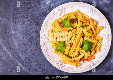 Fusilli Pasta mit Tintenfisch, Zucchini und Karotten, Ansicht von oben. Stockfoto
