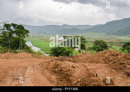 Fluss und Schmutz der Straße mit Bergen und üppiger Vegetation, Bamenda, Kamerun, Afrika. Stockfoto