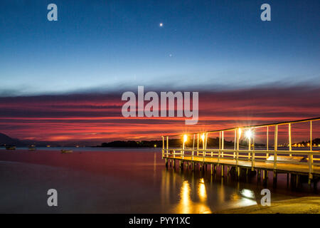 Pier von einem Restaurant in Ribeirao da Ilha Strand, in der Dämmerung. Florianopolis, Santa Catarina, Brasilien. Stockfoto