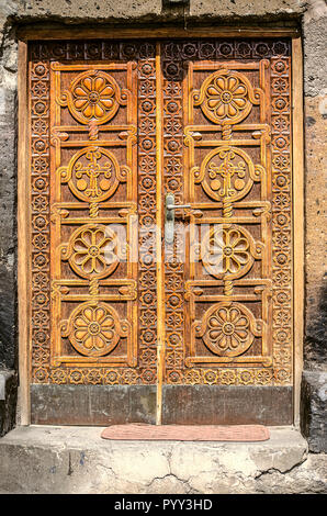 Ashtarak, Armenien, 19. Februar 2018: Eingang Holztür mit geschnitzten Elemente der ethnischen Ornament in der Kirche von St. Marin in der Stadt Ashtarak Stockfoto