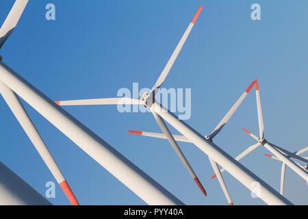 Horizontale gewinkelte Blick auf Zeile weiß äolischen Windenergieanlagen in einem Energie Farm gegen ein strahlend blauer Himmel Stockfoto