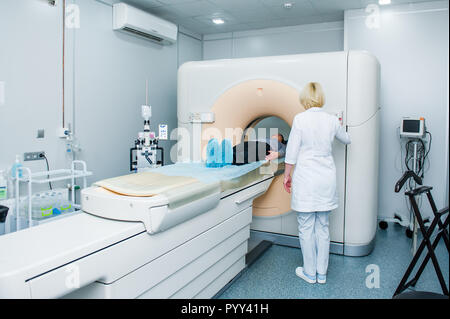 Frau Doktor passt die Computertomographie oder Kernspintomographie Maschine berechnet axial scan mit dem Lügen Patient im Krankenhaus Zimmer Stockfoto