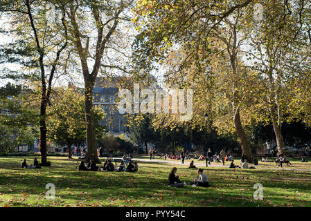 Herbst Russell Square mit Menschen sitzen in der Sonne, Bloomsbury London England Großbritannien UK Stockfoto