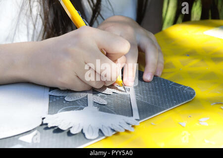 Ein Mädchen schneidet ein Karton Messer mit einer feststehenden Messer. Stockfoto