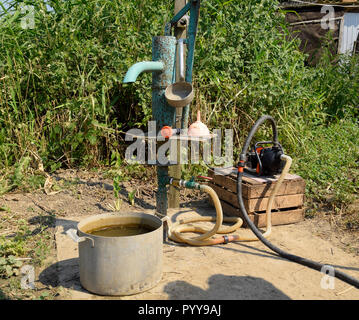 Das Bewässerungssystem im heimischen Garten. Gut mit manueller und automatischer Pumpe. Stockfoto