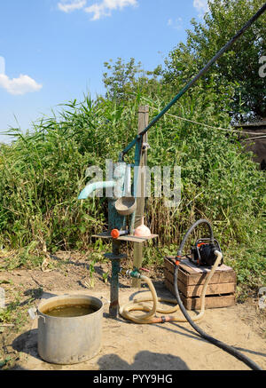 Das Bewässerungssystem im heimischen Garten. Gut mit manueller und automatischer Pumpe. Stockfoto