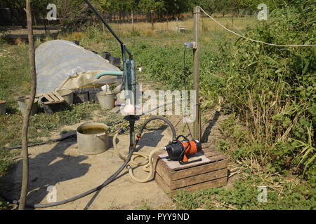 Das Bewässerungssystem im heimischen Garten. Gut mit manueller und automatischer Pumpe. Stockfoto