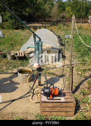 Das Bewässerungssystem im heimischen Garten. Gut mit manueller und automatischer Pumpe. Stockfoto