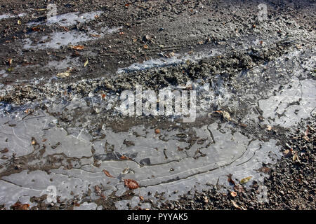 Gefrorenen Pfütze auf unbefestigte Straße Stockfoto