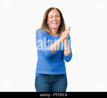 Schöne Frau mittleren Alters tragen winter Pullover über isolierte Hintergrund Klatschen und froh und glücklich applaudieren, lächelt stolz die Hände zusammen Stockfoto