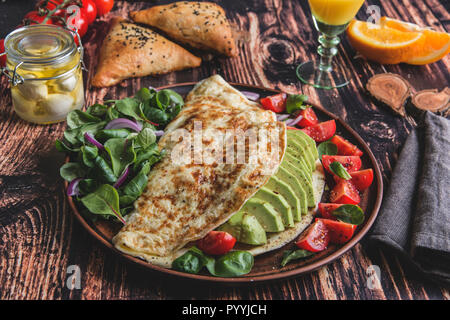 Omelette mit Avocado, Tomate, Mozzarella, Käse, Orangensaft, samsa. Gesunde Ernährung Stockfoto