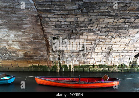 Am späten Nachmittag ein Bild von einem kleinen roten Boot unter den Bögen der Richmond Bridge in London, England günstig erfasst Stockfoto