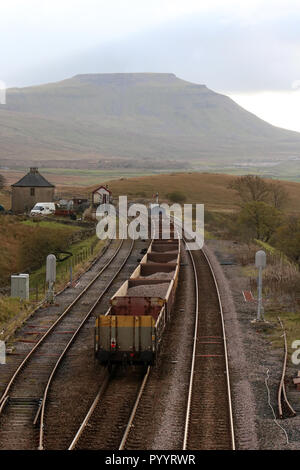 Ingenieure Zug mit alten Sleeper, Schiene, Ballast in Waggons, blea Moor auf Carlisle Railway, die am 30. Oktober 2018, Ingleborough in Distanz zu vereinbaren. Stockfoto