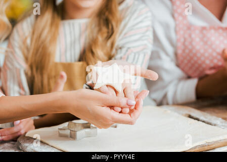 7/8 Schuß des Kindes und der Frau mit sternförmigen Stück Teig Stockfoto